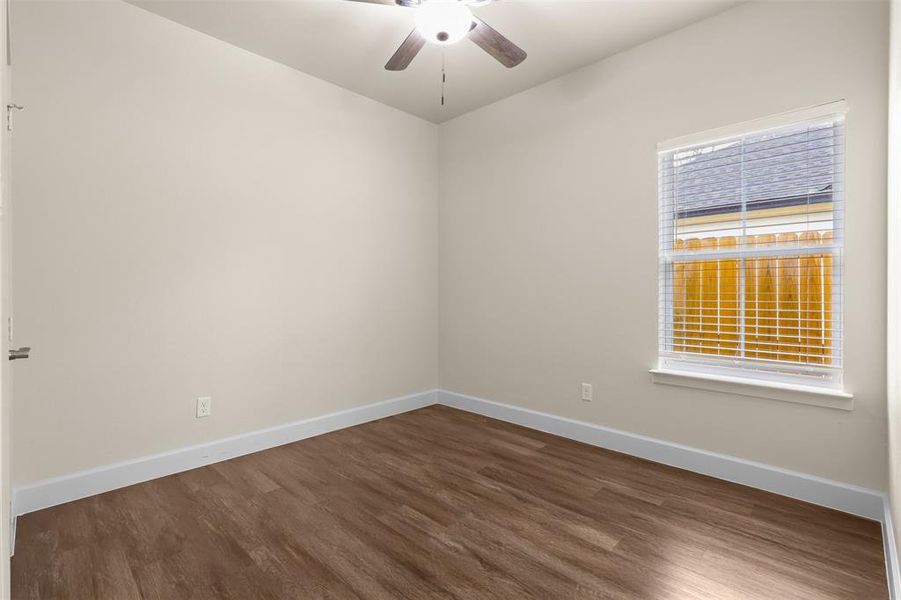 Unfurnished room with dark hardwood / wood-style flooring and ceiling fan