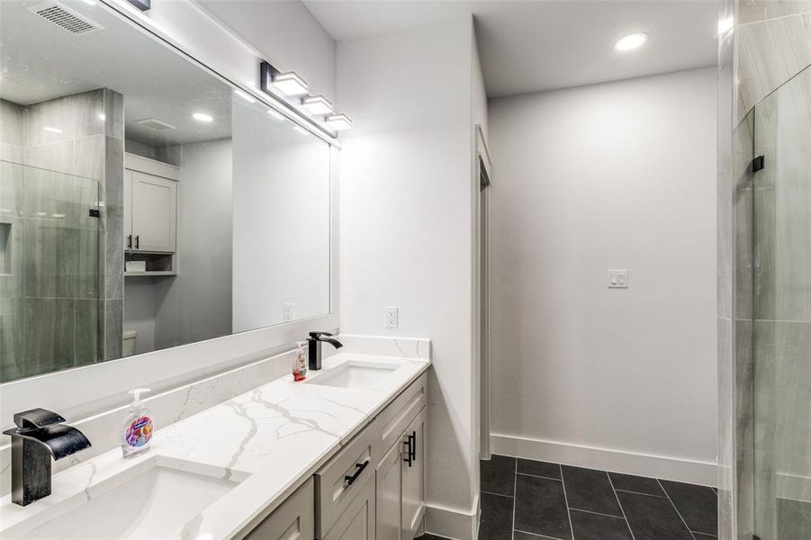 Full bath with tile patterned flooring, a sink, toilet, and a shower stall