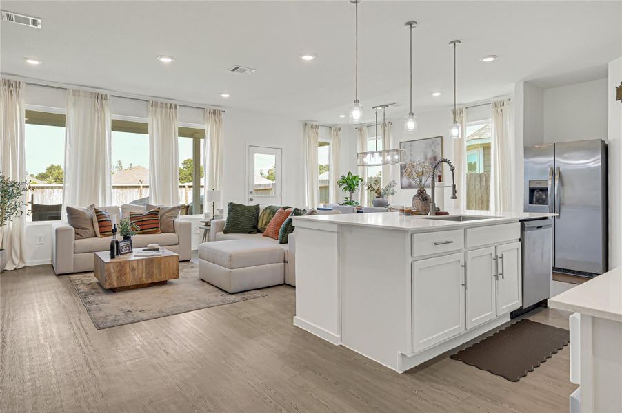Bright and open living space with modern kitchen, featuring sleek white cabinetry, stainless steel appliances, and abundant natural light from large windows. Bright and open living space with modern kitchen, featuring sleek white cabinetry, stainless steel appliances, and abundant natural light from large windows.