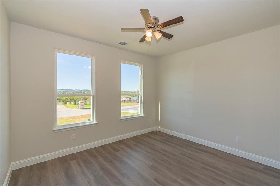 Spare room with dark wood-type flooring and ceiling fan