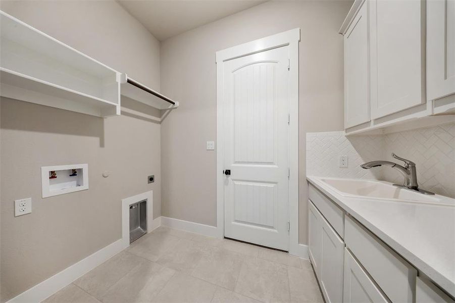 Laundry room with cabinet space, washer hookup, and electric dryer hookup Laundry room with cabinet space, washer hookup, and electric dryer hookup