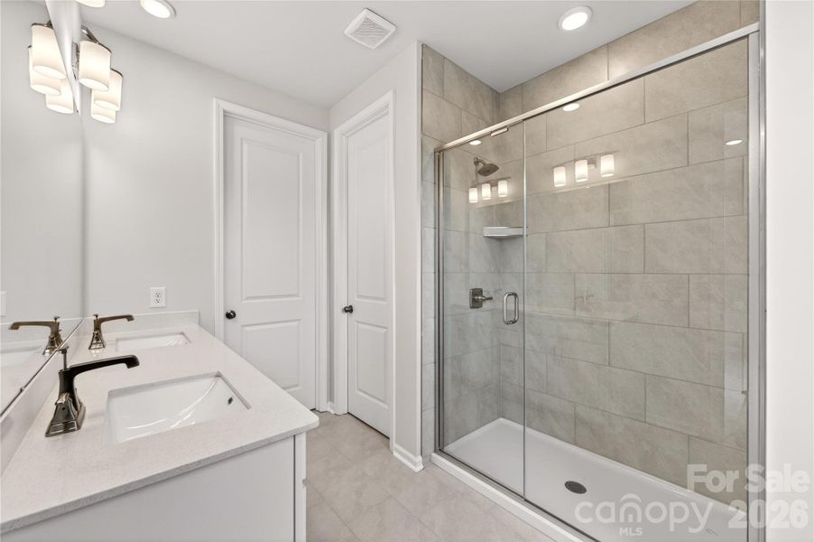 Primary walk-in shower with tiled walls Primary walk-in shower with tiled walls