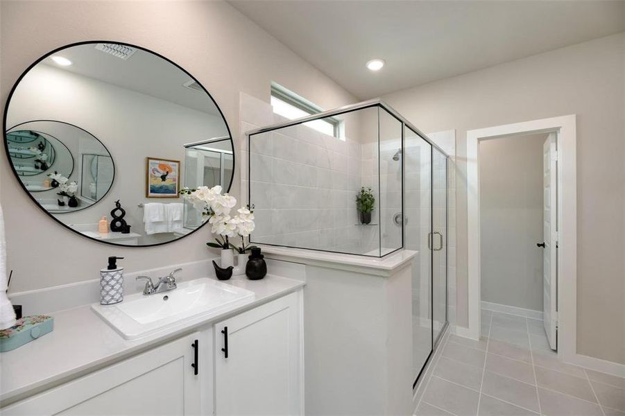 Bathroom featuring vanity, a shower stall, and light tile patterned floors Bathroom featuring vanity, a shower stall, and light tile patterned floors