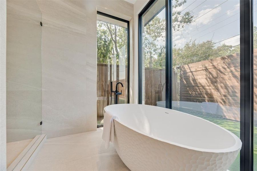 Bathroom featuring a tub to relax in, tile walls, and tile patterned flooring