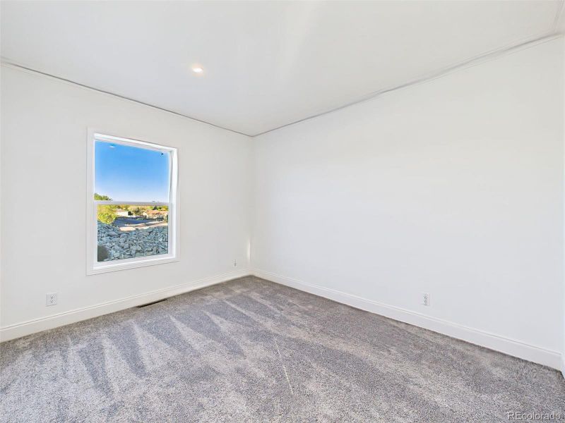 Unstaged version bedroom 3 highlighting new carpet, recessed lighting, and neutral palette. Unstaged version bedroom 3 highlighting new carpet, recessed lighting, and neutral palette.