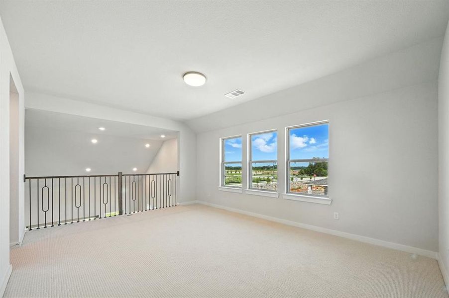 Carpeted spare room featuring vaulted ceiling and recessed lighting Carpeted spare room featuring vaulted ceiling and recessed lighting