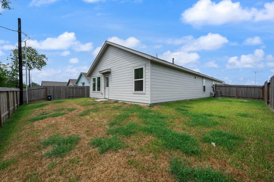 Wide rear view highlights the single-story exterior, backyard space, and privacy fencing surrounding the property. Wide rear view highlights the single-story exterior, backyard space, and privacy fencing surrounding the property.