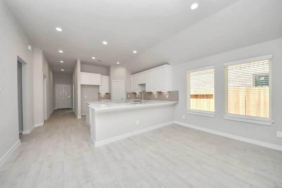 Make memories gathered around the table with your family and friends! This spacious dining room features elegant flooring, custom paint, and adjacent to family room and kitchen for open concept feel. Sample photo of completed home with similar floor plan. Actual colors and selections may vary.