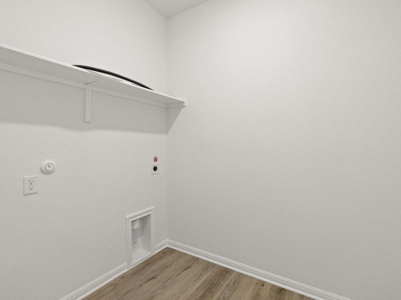 Dedicated laundry area featuring a built-in white shelf, electrical outlets, and utility hookups