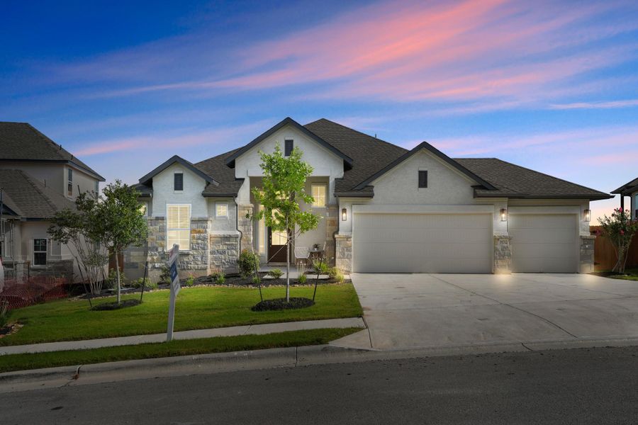 A well-maintained facade with a stone and stucco blend, featuring an inviting entrance and integrated garages.