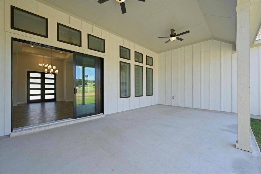 Covered back patio looking into the large sliding glass doors to the family room.