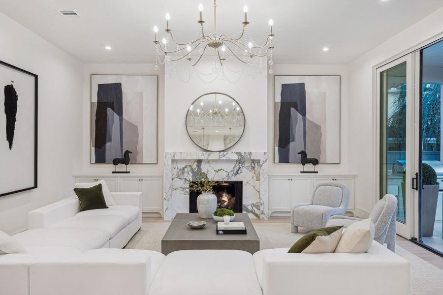 [Great Room] European wide plank white oak floors create a sense of elegance and sophistication. The great room showcases a gas fireplace with honed Italian marble with Pella sliding door to the veranda/summer kitchen.