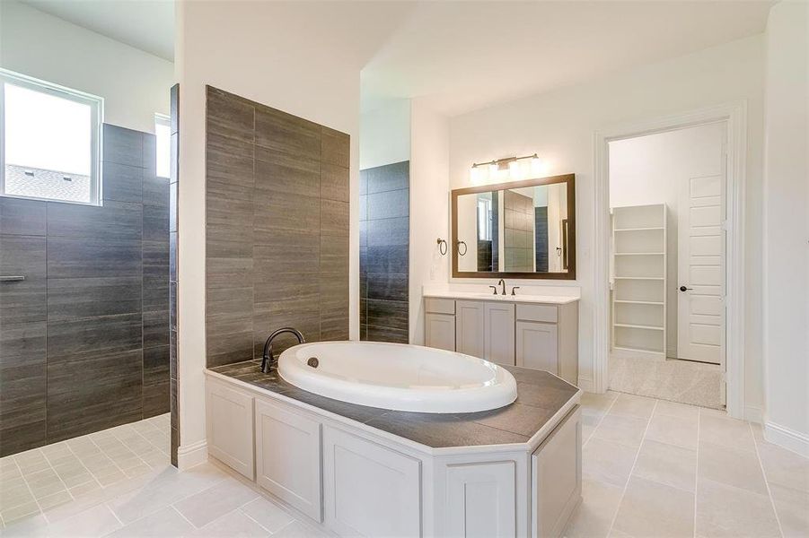 Bathroom featuring vanity, tile patterned flooring, and separate shower and tub