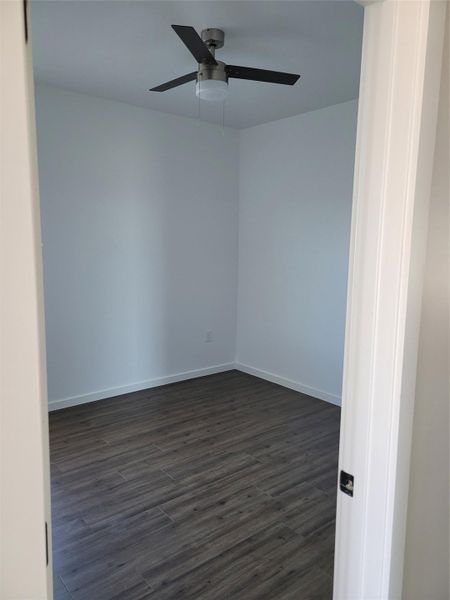 A quiet room features sleek flooring and a contemporary ceiling fan.