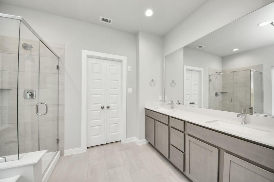 Elevate your daily routine at the elegant vanity, now equipped with double sinks, light countertops, modern hardware, and beautiful recessed lights. Sample photo of completed home with similar floor plan. Actual colors and selections may vary. Elevate your daily routine at the elegant vanity, now equipped with double sinks, light countertops, modern hardware, and beautiful recessed lights. Sample photo of completed home with similar floor plan. Actual colors and selections may vary.