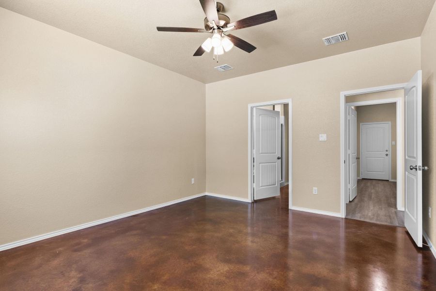 Unfurnished bedroom with concrete flooring and a ceiling fan
