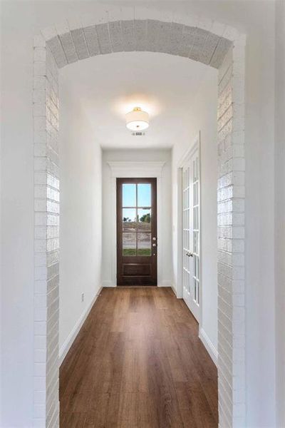 Doorway with wood finished floors, french doors, and arched walkways Doorway with wood finished floors, french doors, and arched walkways