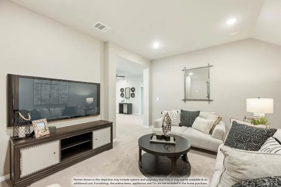 Living room with wall-mounted TV, dark wood media console, light gray sofa, and round coffee table on beige carpet