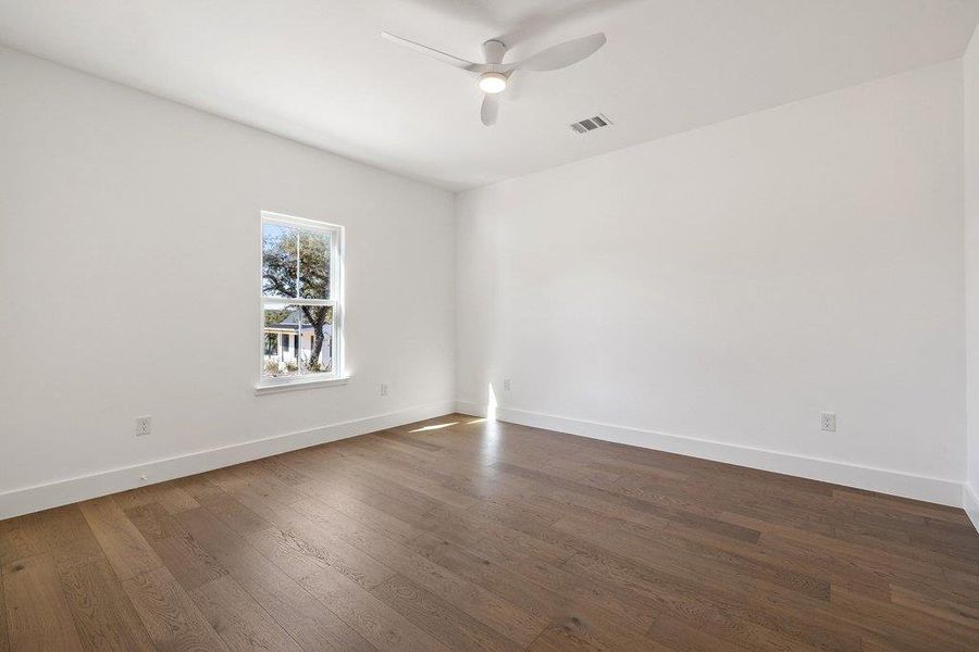 Spare room with dark wood-style flooring and a ceiling fan