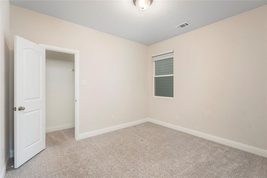 Empty room with light colored carpet and baseboards
