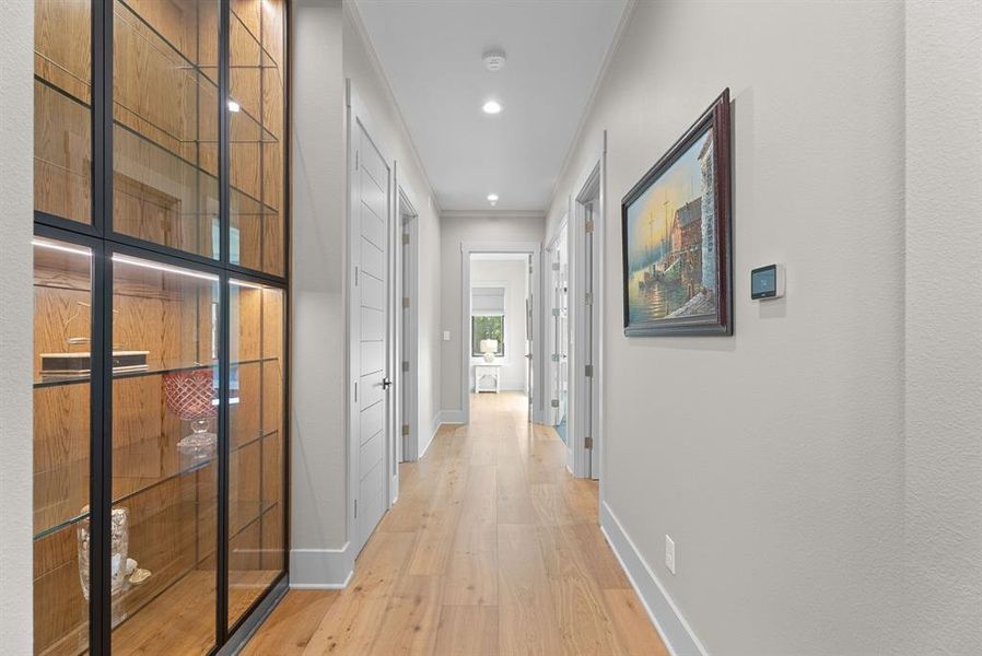 Hall featuring light wood-type flooring, crown molding, and recessed lighting