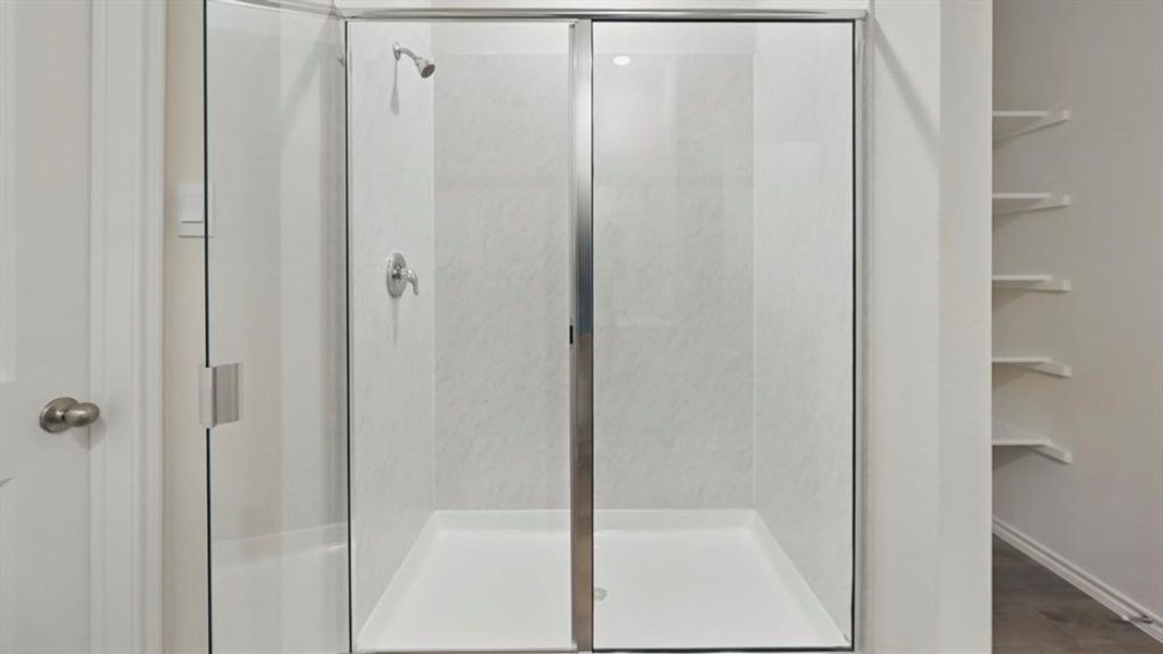 Full bathroom with a stall shower and dark wood-type flooring