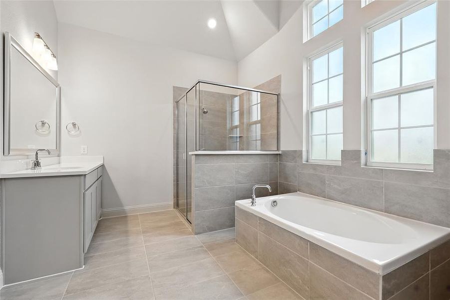 Bathroom featuring vanity, a garden tub, light tile patterned flooring, a shower stall, and recessed lighting