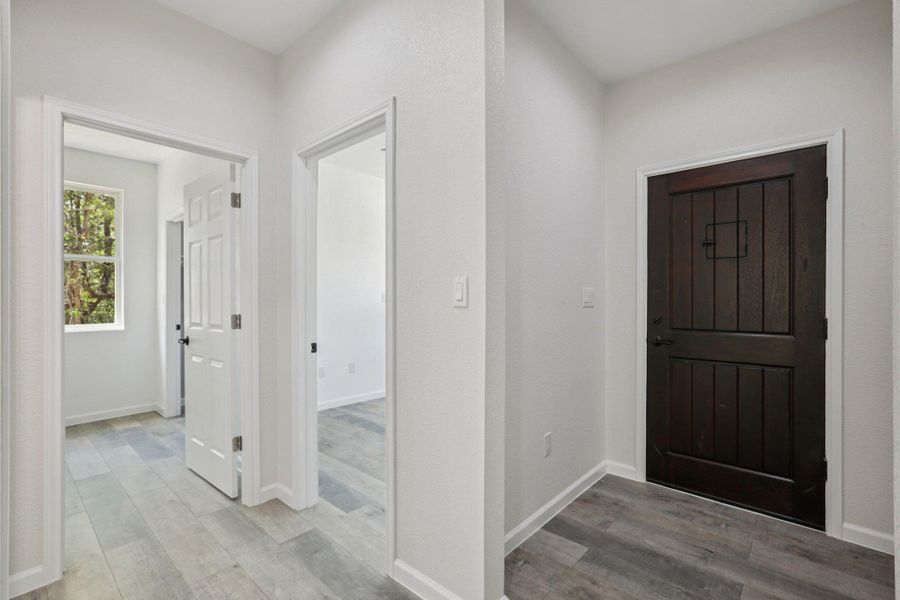 Foyer featuring light wood-type laminate flooring and baseboards