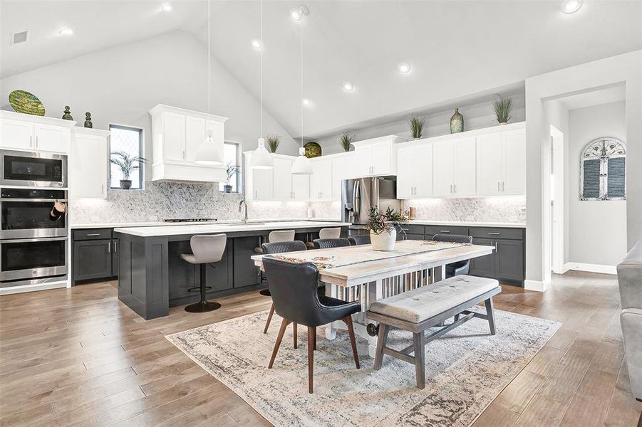 Dining area featuring high vaulted ceiling, light wood-type flooring, and recessed lighting Dining area featuring high vaulted ceiling, light wood-type flooring, and recessed lighting