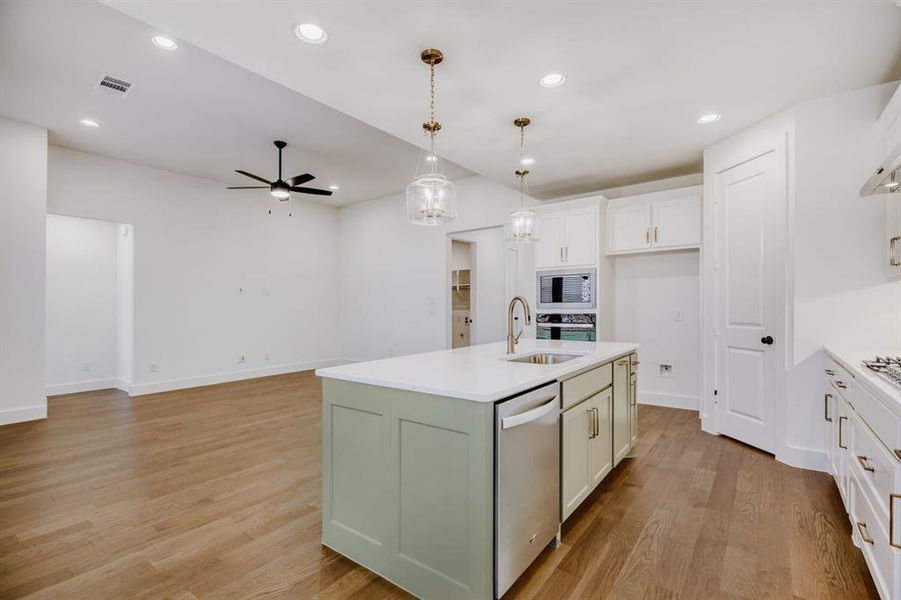 Contemporary kitchen island with a light green finish and white countertop