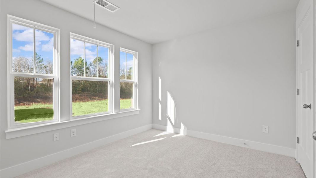 Superior comfort in this light-filled bedroom with plush carpeting and thoughtfully placed large windows