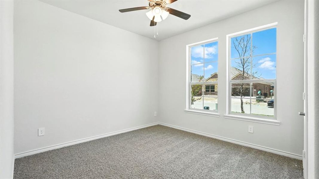Spare room with carpet and a ceiling fan