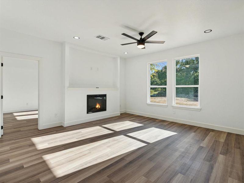 Unfurnished living room with ceiling fan and wood-type flooring