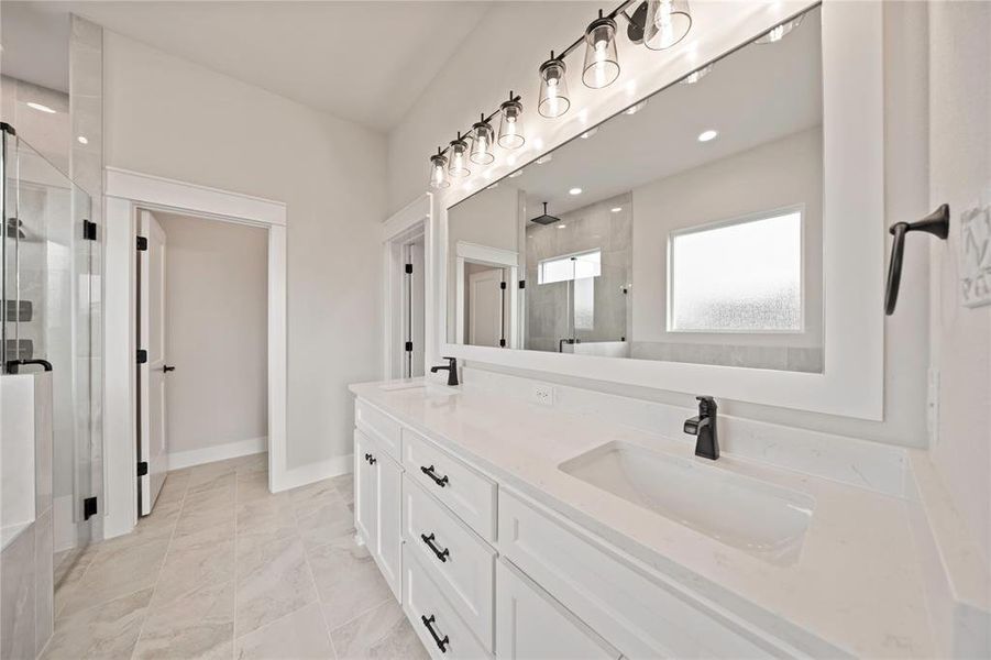 Full bath featuring double vanity, a stall shower, and marble finish flooring Full bath featuring double vanity, a stall shower, and marble finish flooring