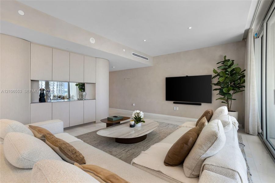 Custom floor-to-ceiling cabinetry with integrated mirror backsplash, recessed lighting, and large-format tile flooring