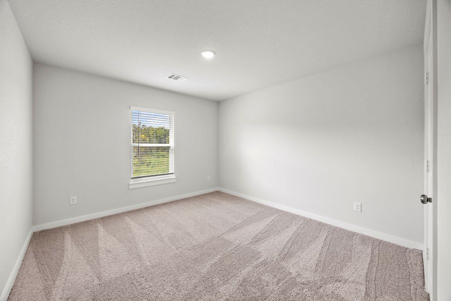 A room with a carpet and a window.