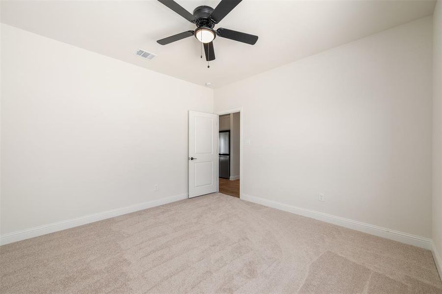 Unfurnished room with light colored carpet and ceiling fan