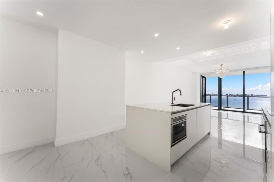 Modern chef’s kitchen equipped with custom Italian cabinetry, premium Miele appliances, integrated stone countertops, and a waterfall island perfect for entertaining.