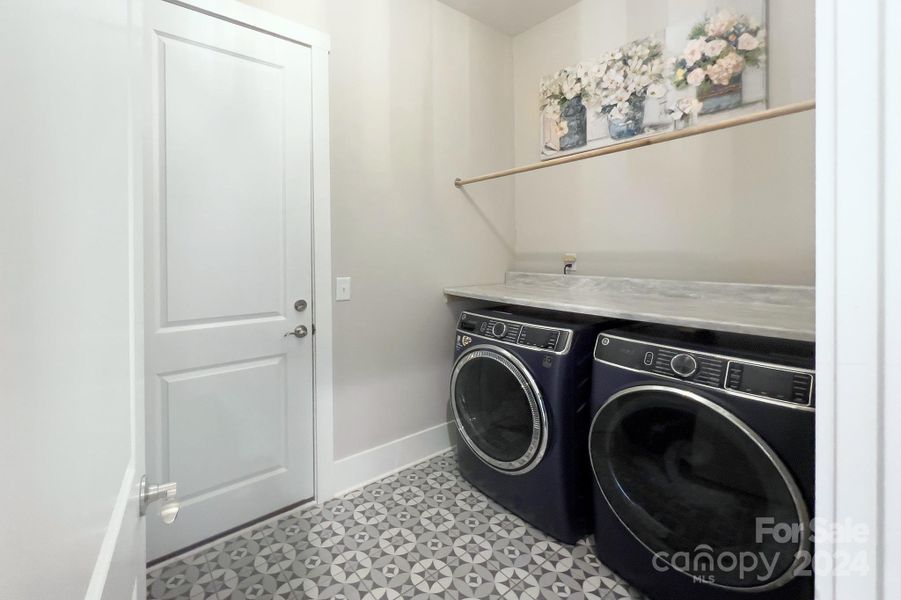 Laundry room has a folding/hanging area, utility sink and cabinetry