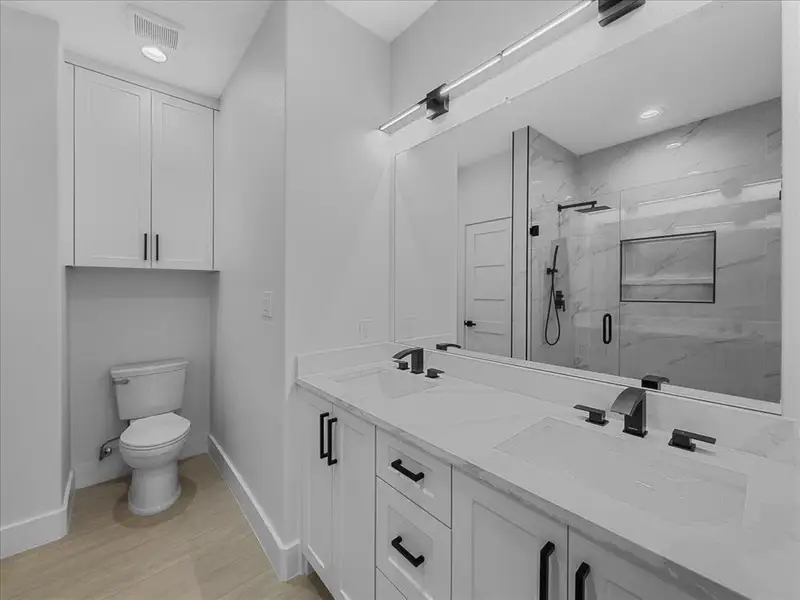 Full bathroom featuring a marble finish shower, double vanity, recessed lighting, and light wood-style flooring Full bathroom featuring a marble finish shower, double vanity, recessed lighting, and light wood-style flooring