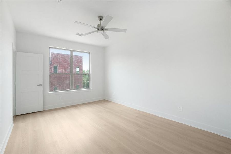 Spare room with light wood finished floors, baseboards, and ceiling fan