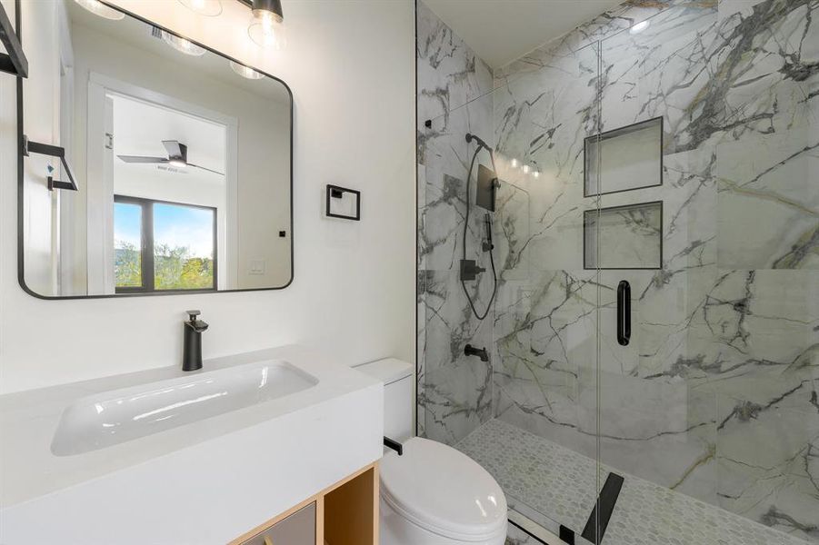 Bathroom featuring vanity and a marble finish shower