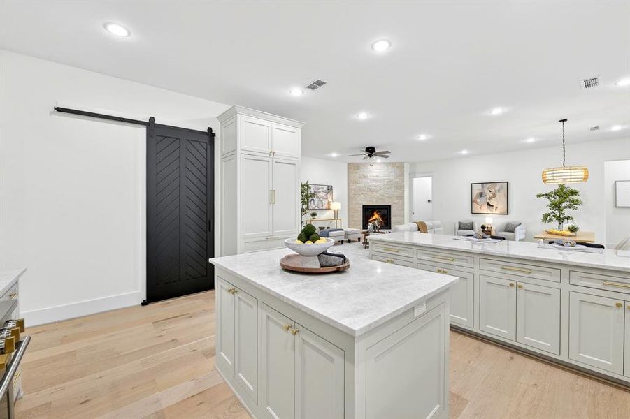 Barn door leads to oversized pantry with ample shelving and space for appliances to be stored out of sight!