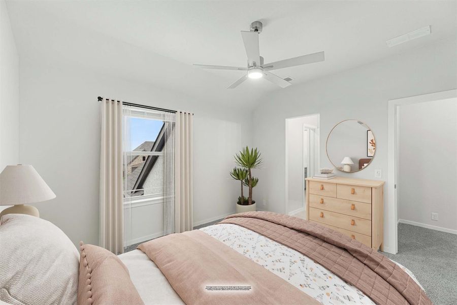 Bedroom with vaulted ceiling, ceiling fan, carpet flooring, wood dresser, and a window with sheer curtains