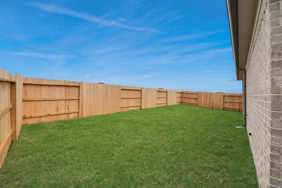 Discover the charm of this spacious backyard featuring a delightful covered patio. With ample room for both play and relaxation, it's the perfect outdoor haven. Tailor this space to your liking with patio furniture, a BBQ pit, and more. The potential for creating your dream outdoor living area is limitless!