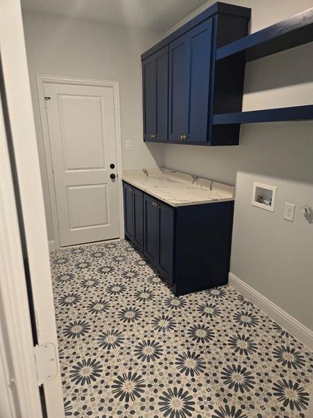 Laundry area with cabinets, light tile patterned floors, and hookup for a washing machine