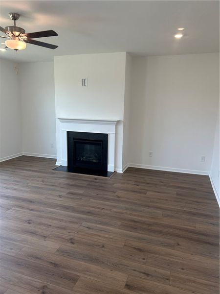 A refined fireplace and wide plank flooring comple