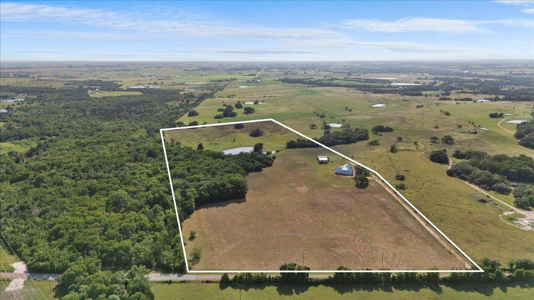 Aerial view of sparsely populated area featuring property boundaries highlighted
