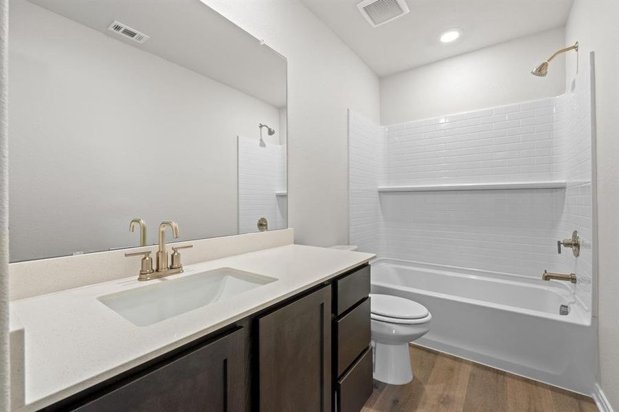 Full bathroom with toilet, hardwood / wood-style flooring, vanity, and shower / bathtub combination