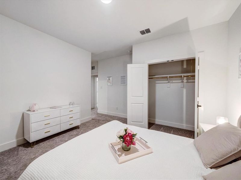 Bedroom with dark colored carpet and a closet Bedroom with dark colored carpet and a closet